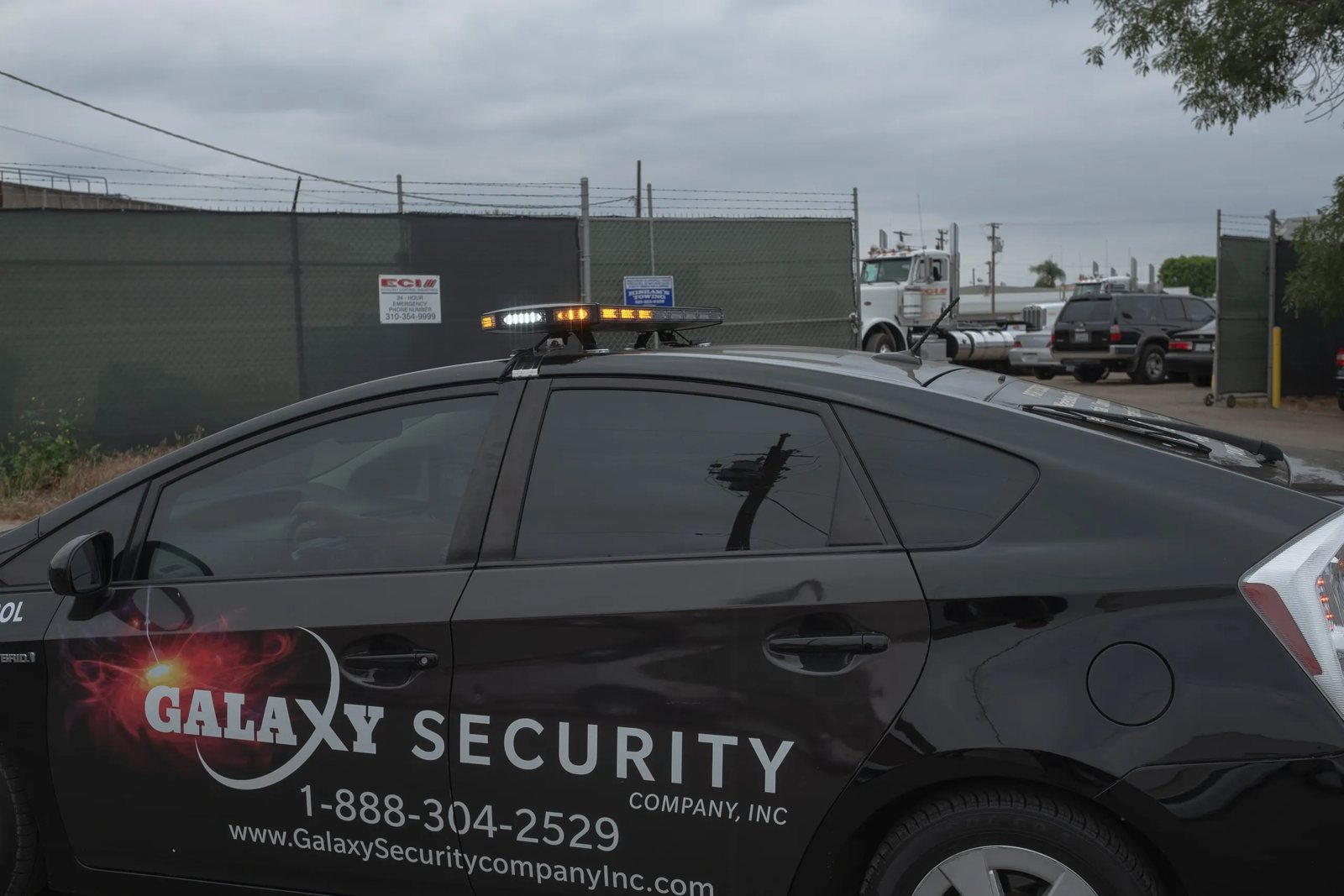 A Galaxy patrol car in a fenced truck yard