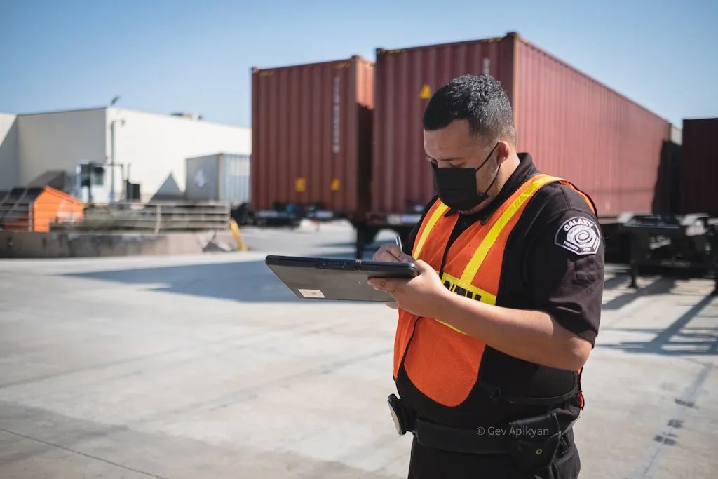 A Galaxy officer checking a container trailer with a tablet