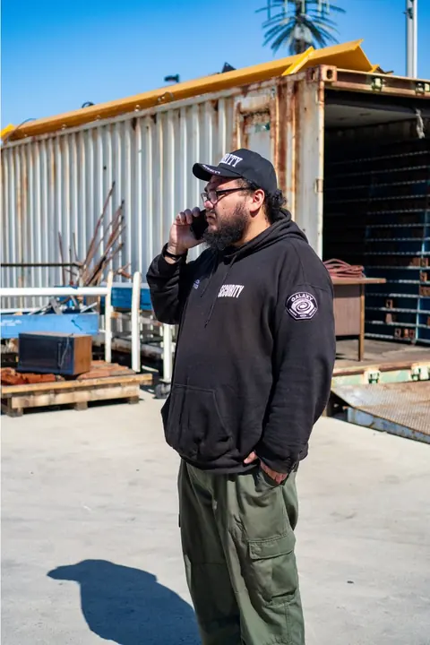 A Galaxy officer on the phone in a container yard